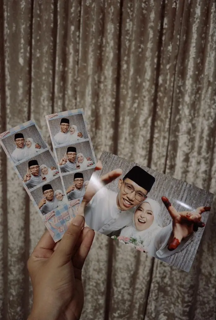 A guest holding freshly printed firphotobooth photostrips